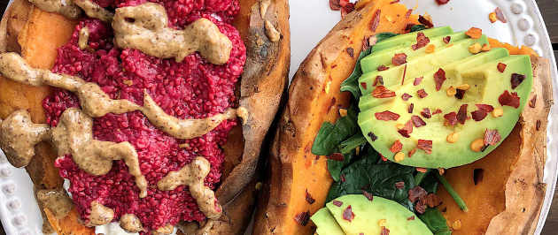 Two stuffed sweet potaotes with raspberry chia jam, almond butter, spinach, and avocado