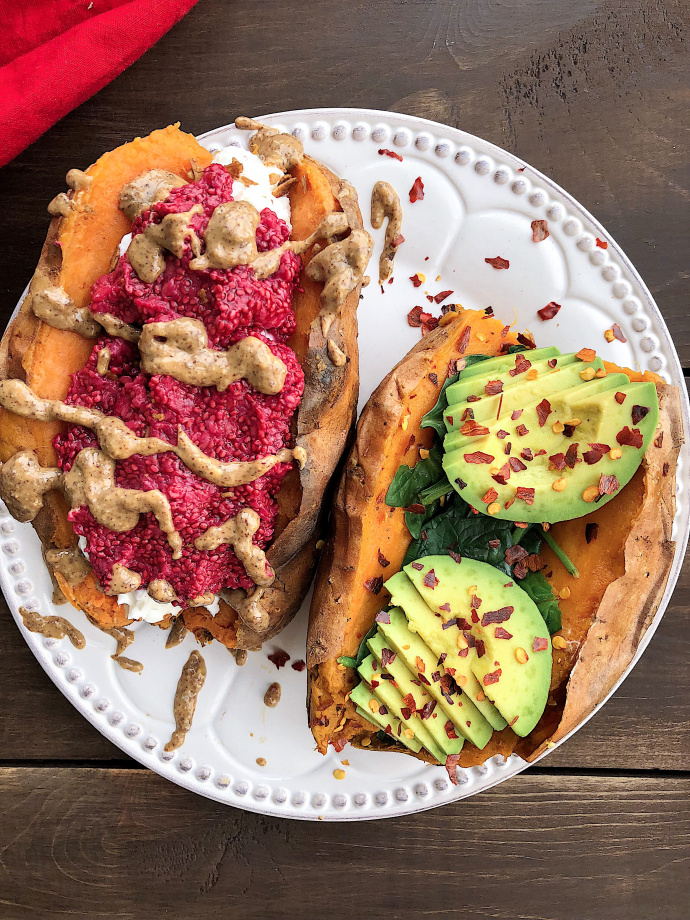 Two stuffed sweet potaotes with raspberry chia jam, almond butter, spinach, and avocado 