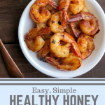 honey garlic shrimp in a white bowl on a wood background