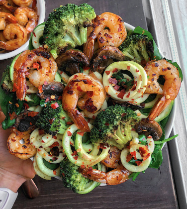 honey garlic shrimp in a white bowl on a wood background