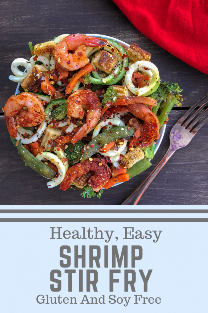 Shrimp with stir fry veggies and zucchini noodles on a wood background.