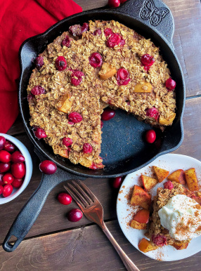 gluten free baked oatmeal with yogurt on top in a cast iron skillet on a wood board .