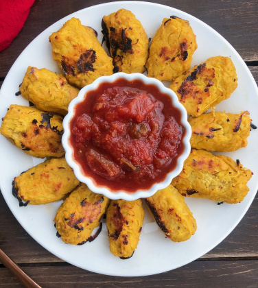 spaghetti squash tater tots on a white plate with salsa in a cup in the middle