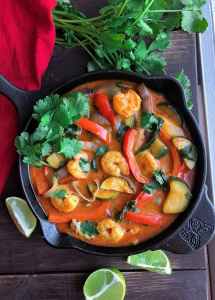 Coconut shrimp curry with veggies in a black cast iron skillet