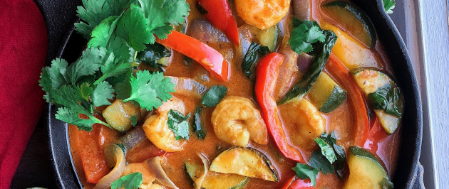 Coconut shrimp curry with veggies in a black cast iron skillet