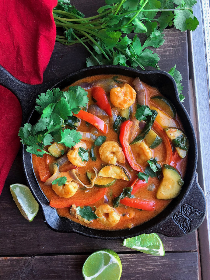 Coconut shrimp curry with veggies in a black cast iron skillet