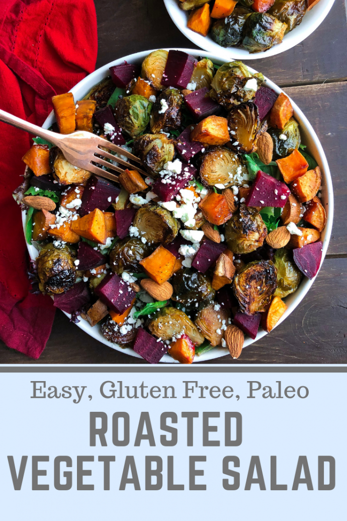 Roasted beet, brussels, sweet potatoes, feta salad in a white bowl on a brown board