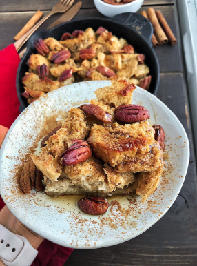 Maple Pecan French Toast bake on a white plate against a wood background