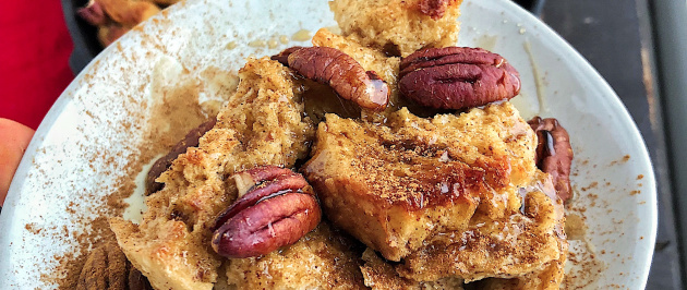 Maple Pecan French Toast bake on a white plate against a wood background