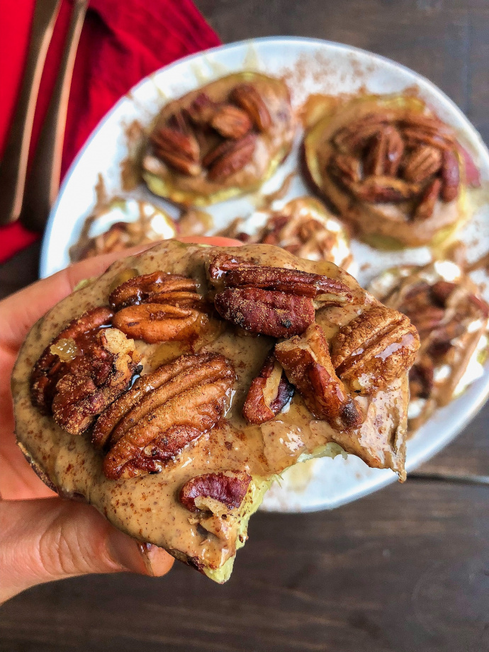 pecans, almond butter, yogurt, and cinnamon on sweet potatoes on a white plate