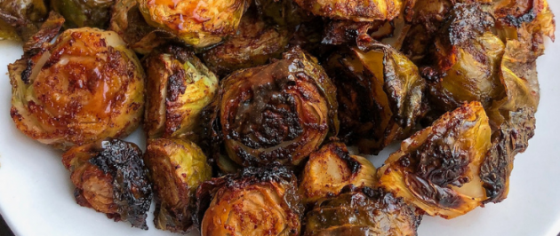 barbecue brussel sprouts on a white plate.