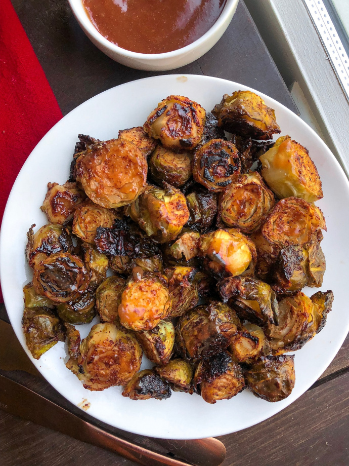 barbecue brussel sprouts on a white plate. 