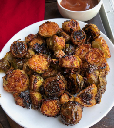 barbecue brussel sprouts on a white plate.