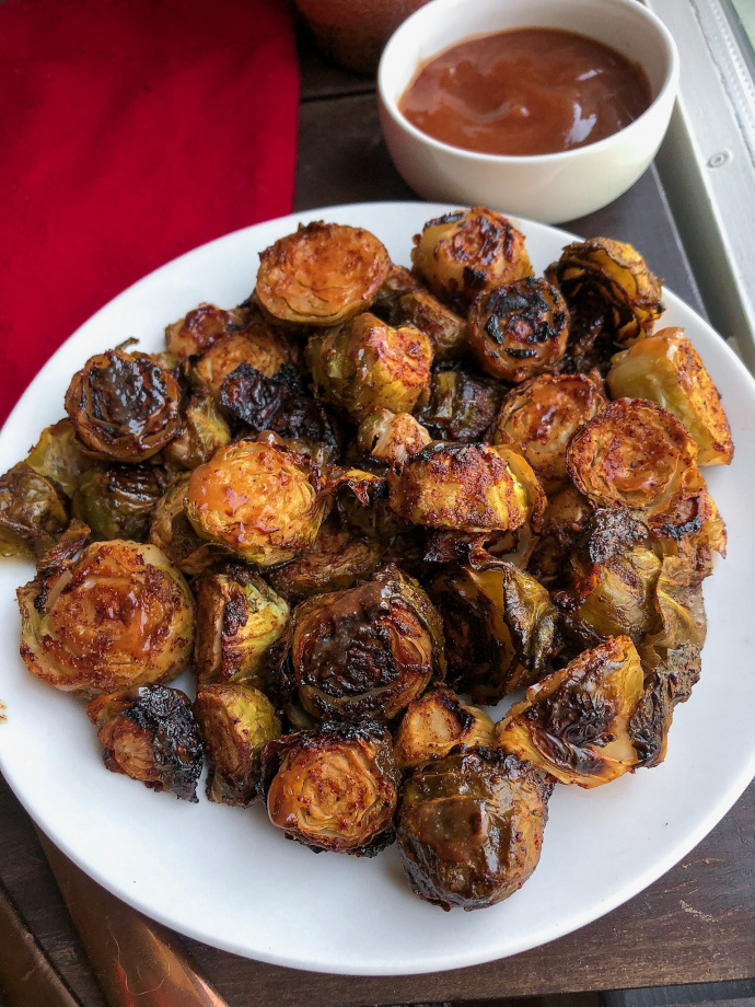 barbecue brussel sprouts on a white plate.