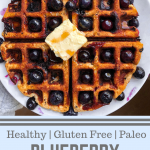 Paleo blueberry waffle with blueberries and butter on top on a white plate
