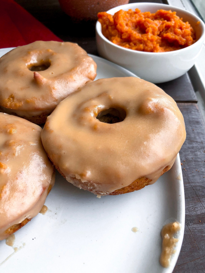 paleo pumpkin donuts on a white plate with a 3 ingredient icing