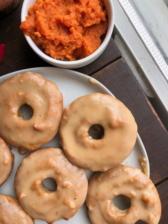 paleo pumpkin donuts on a white plate with a 3 ingredient icing