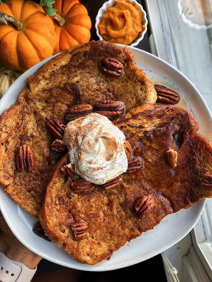 vegan maple pumpkin french toast on a white plate with pecans
