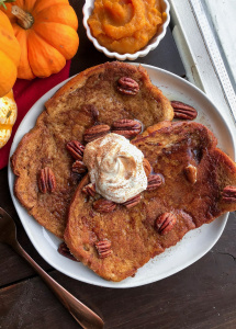 vegan maple pumpkin french toast on a white plate with pecans