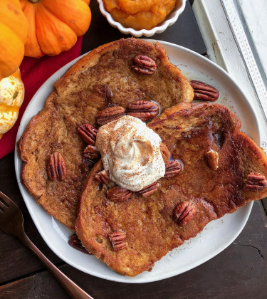 vegan maple pumpkin french toast on a white plate with pecans