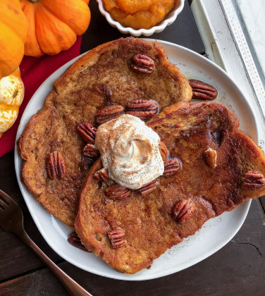 vegan maple pumpkin french toast on a white plate with pecans