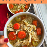 healthy chicken and rice soup with cauliflower rice and carrots in a white bowl