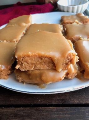 vegan sugar cookie bars with an easy healthy icing on top on a white plate