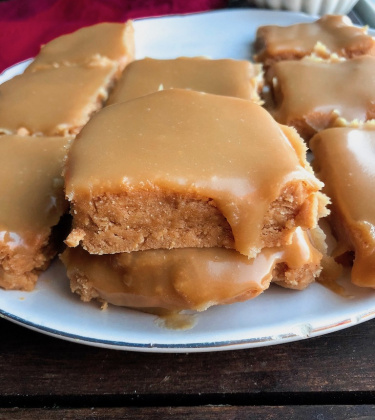 vegan sugar cookie bars with an easy healthy icing on top on a white plate