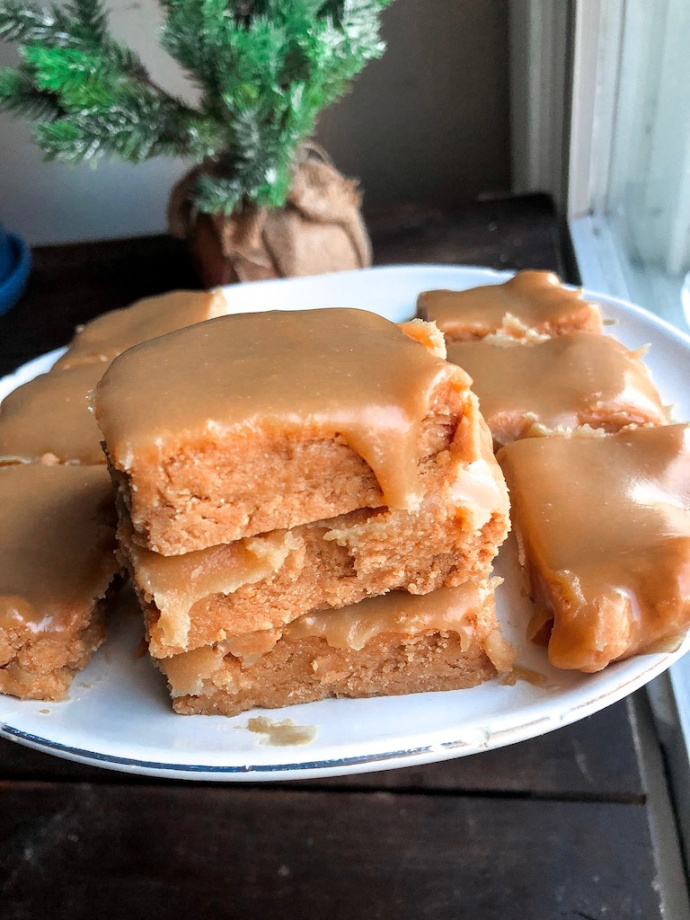 vegan sugar cookie bars with an easy healthy icing on top on a white plate