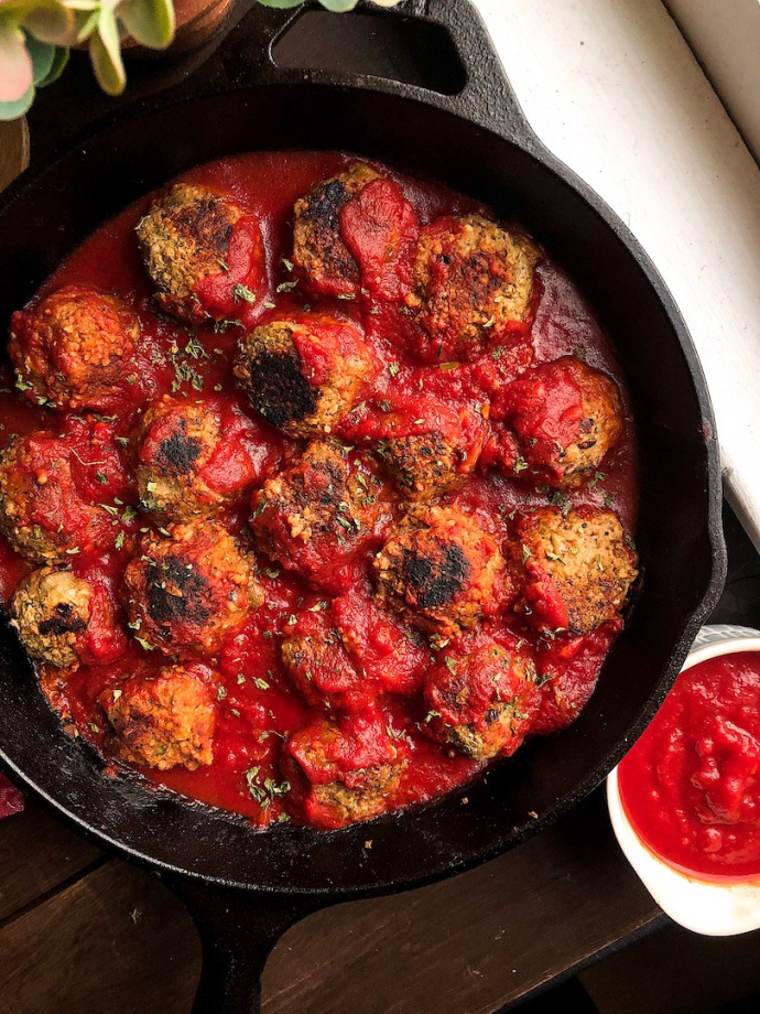 vegan meatballs in a red sauce in a cast iron pan