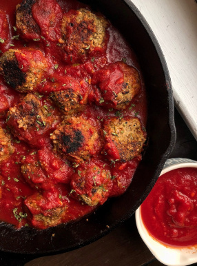 vegan meatballs in a red sauce in a cast iron pan