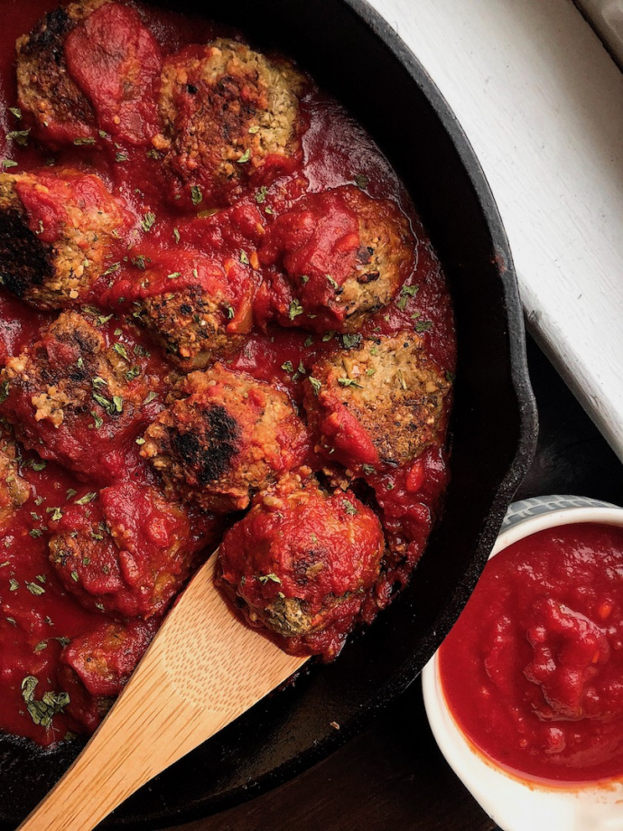 vegan meatballs in a red sauce in a cast iron pan