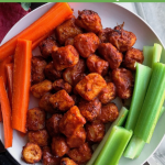 air fried bbq cauliflower on a white plate with carrots and celery