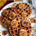 paleo waffles on a white plate with peanut butter and bananas on top