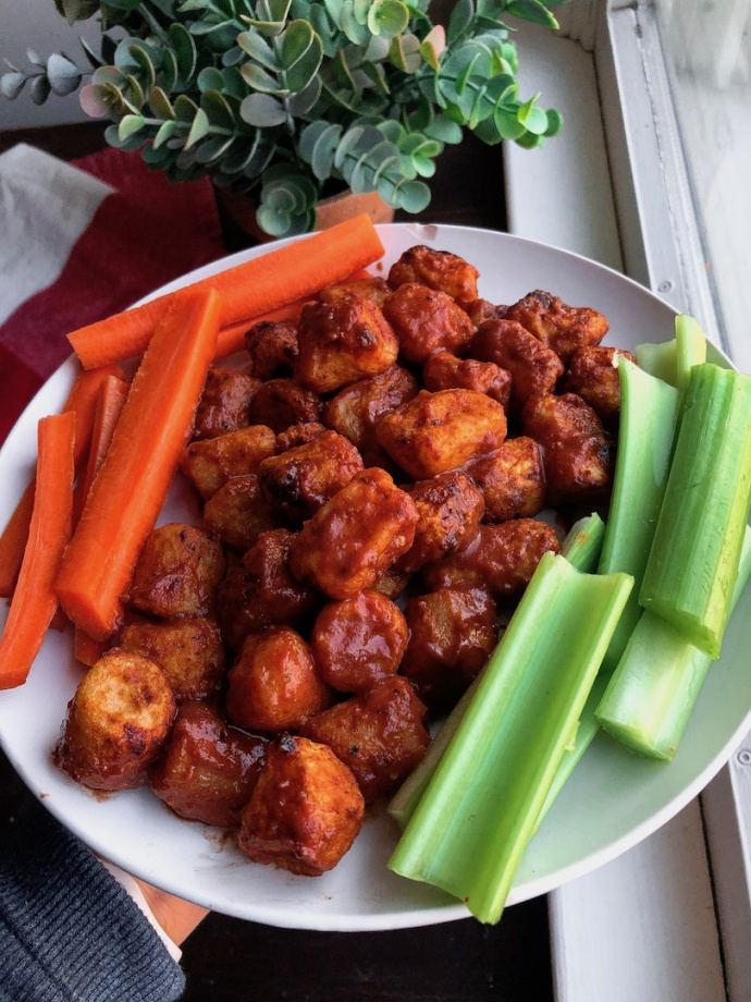 air fried bbq cauliflower on a white plate with carrots and celery