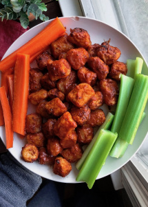 air fried bbq cauliflower on a white plate with carrots and celery