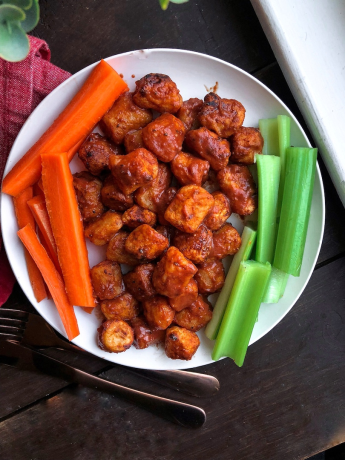 air fried bbq cauliflower on a white plate with carrots and celery