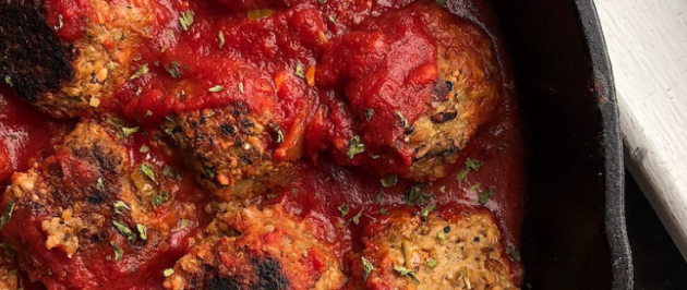 vegan meatballs in a red sauce in a cast iron pan